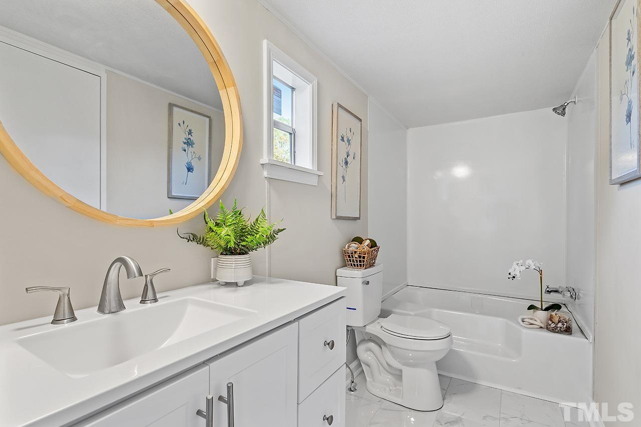 313 Smith Road Smithfield, NC 27577 - Photo 8 of 36 a bathroom with a sink a toilet and mirror