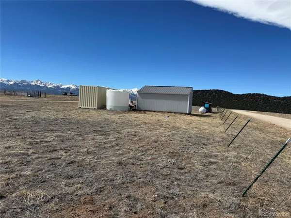 a view of a dry yard with wooden fence