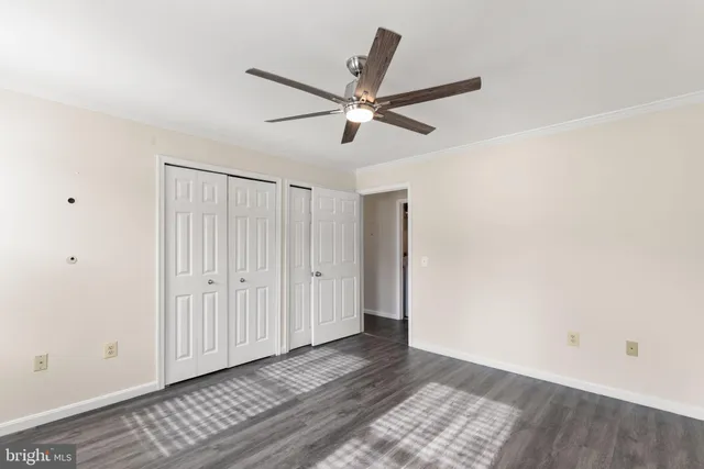 a view of a livingroom with a ceiling fan and wooden floor