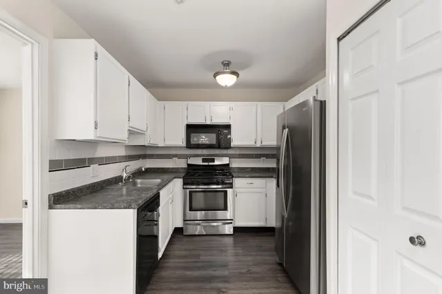 a kitchen with stainless steel appliances granite countertop a stove a refrigerator and a sink