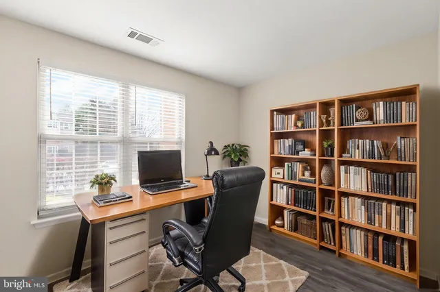 a view of a workspace with a bookshelf and a workspace