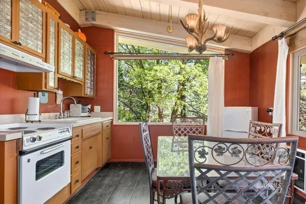 a kitchen with a stove a sink and a wooden cabinets