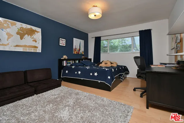 a bedroom with furniture and a wooden floor