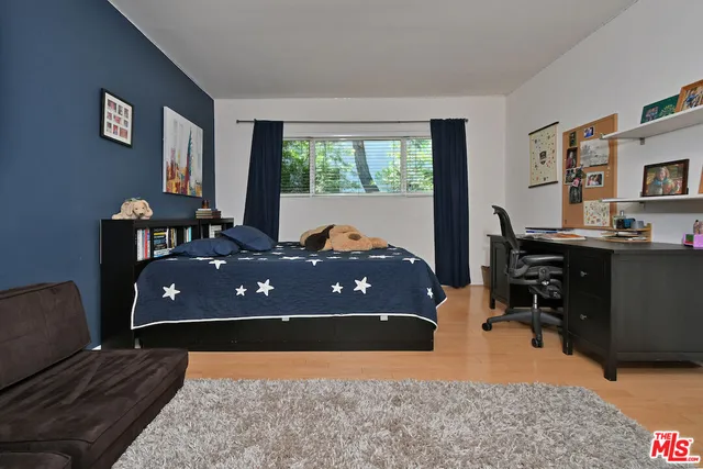 a bedroom with a bed and a large window