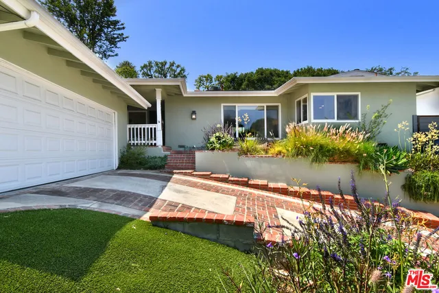 a front view of a house with a potted plant