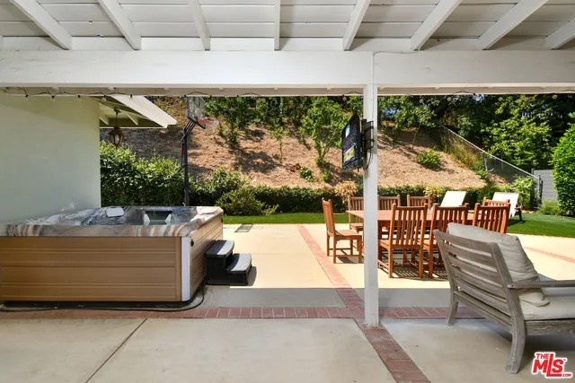 a white bench sitting in the grass near a house