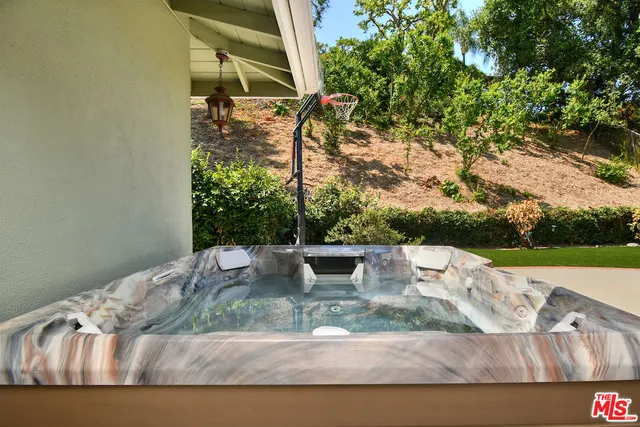 a white bench sitting in the grass near a house