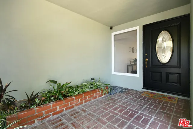 a view of a hallway to a livingroom with wooden floor and a rug
