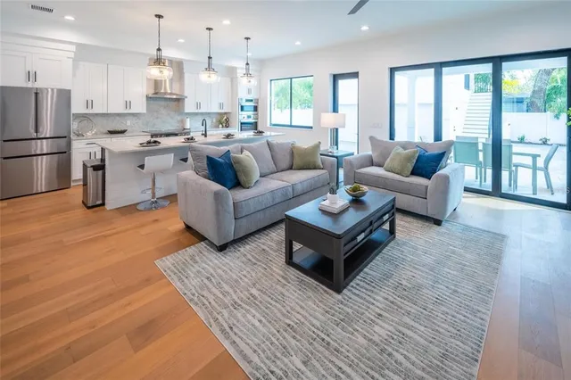 a kitchen with stainless steel appliances granite countertop a sink a stove and white cabinets