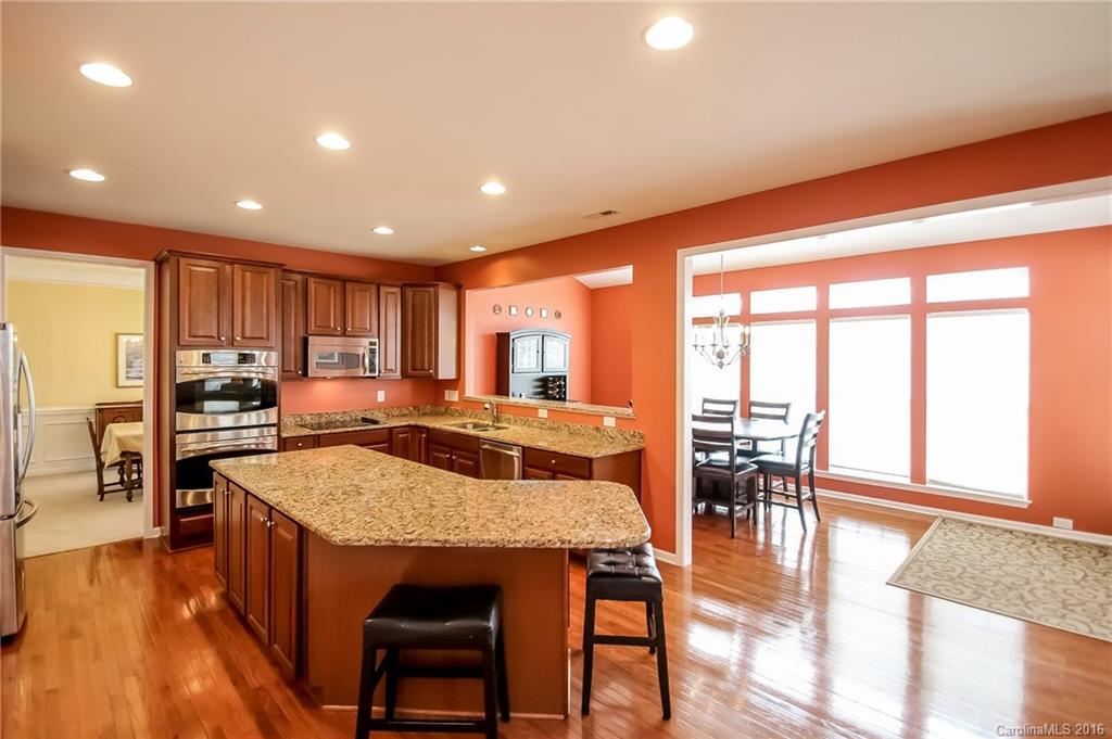 382 Fischer Road Fort Mill, SC 29715 - Photo 4 of 24 a kitchen with stainless steel appliances granite countertop table chairs and wooden floor