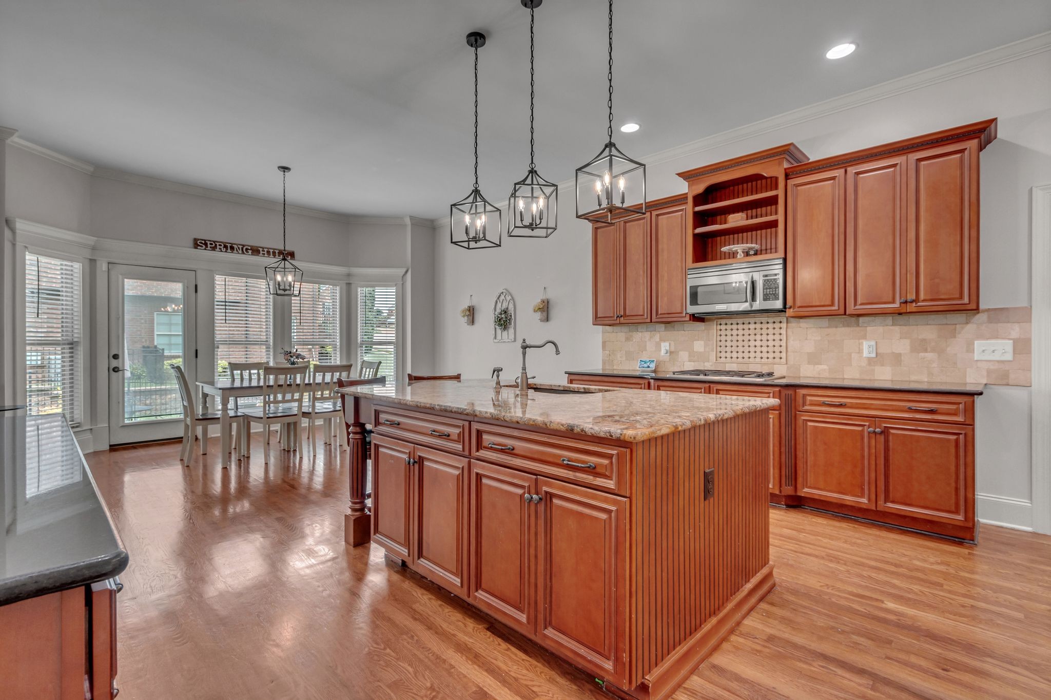 1051 Fitzroy Circle Spring Hill, TN 37174 - Photo 19 of 38 a kitchen with stainless steel appliances granite countertop a stove a refrigerator a sink a dining table and chairs with wooden floor