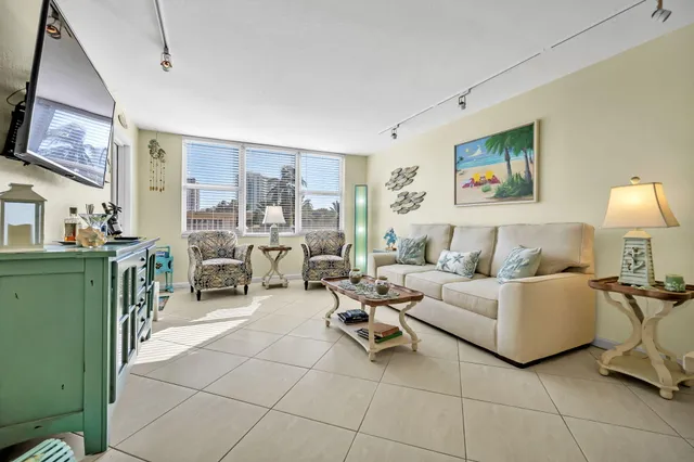 a living room with furniture a flat screen tv and kitchen view
