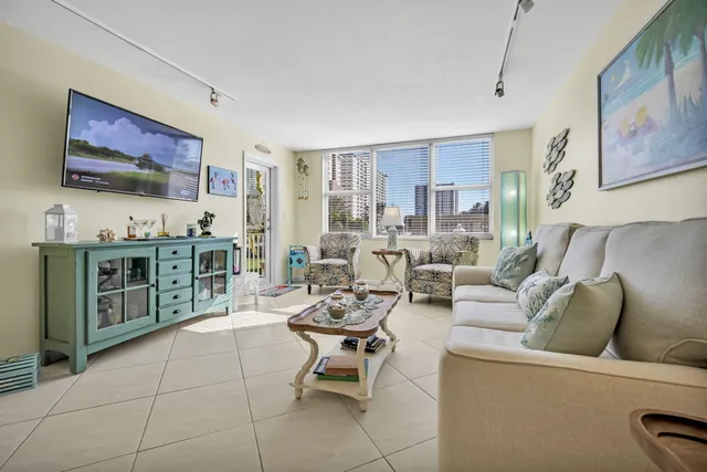 a living room with furniture and a dining table with potted plants