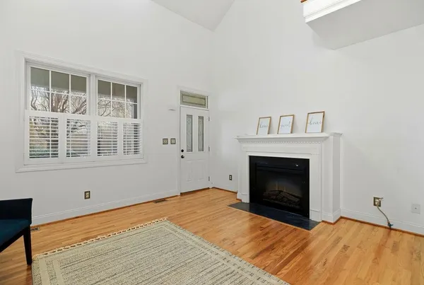 a view of empty room with wooden floor and fireplace