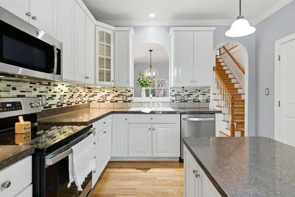 a kitchen with granite countertop a sink and a stove top oven