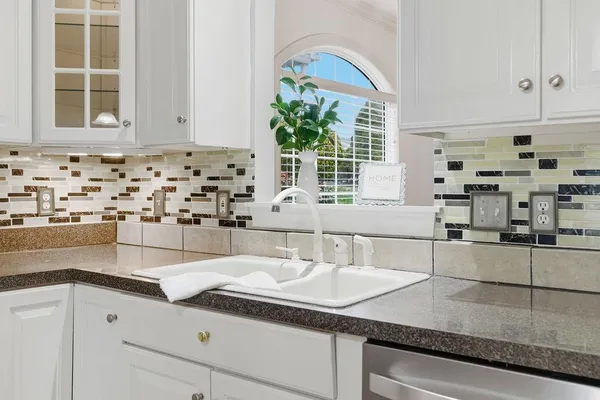 a kitchen with stainless steel appliances granite countertop a sink and a white cabinets