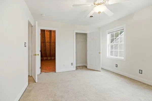 an empty room with chandelier fan