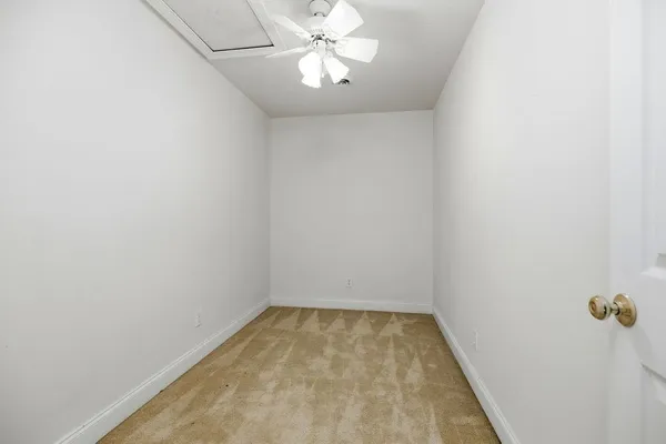 an empty room with a chandelier fan