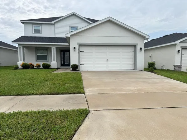 a front view of a house with a yard and garage