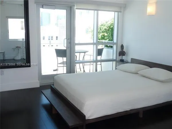 a large bed sitting in a bedroom next to a window