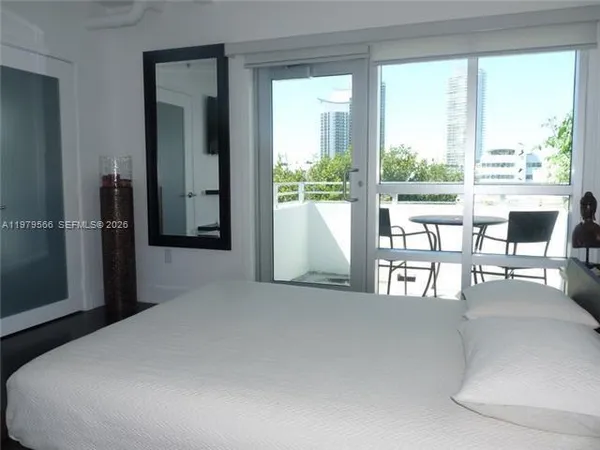 a bedroom with furniture and large windows