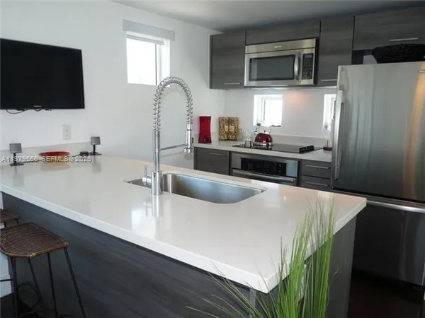 a kitchen with stainless steel appliances a microwave a sink and a refrigerator