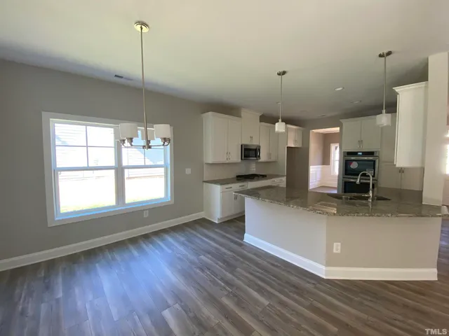 a large kitchen with kitchen island a counter space a sink a window and stainless steel appliances
