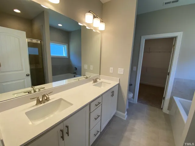 a bathroom with a double vanity sink and a mirror