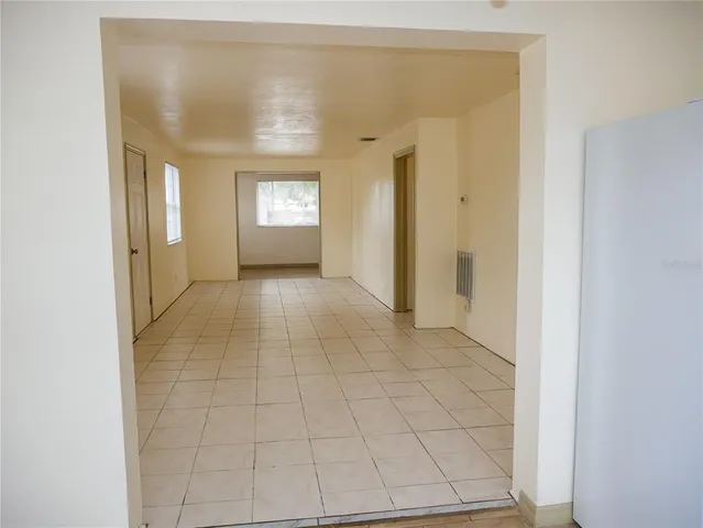 a view of a hallway with wooden floor and a bathroom