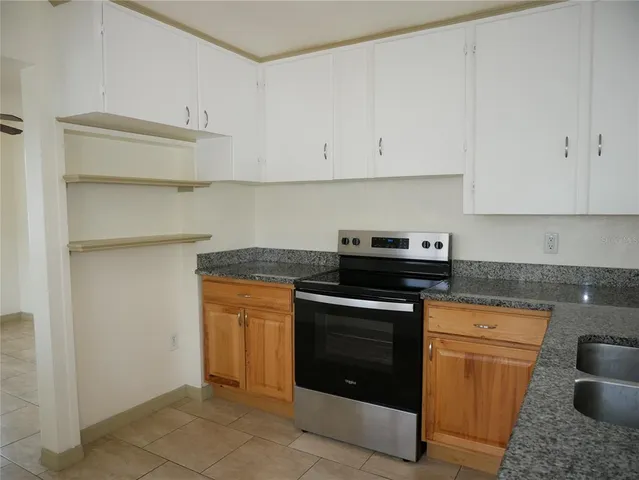 a kitchen with granite countertop white cabinets and stainless steel appliances