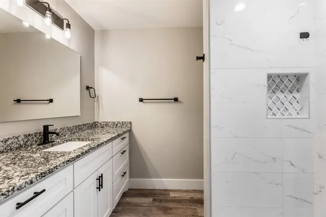 a bathroom with a granite countertop sink and a mirror