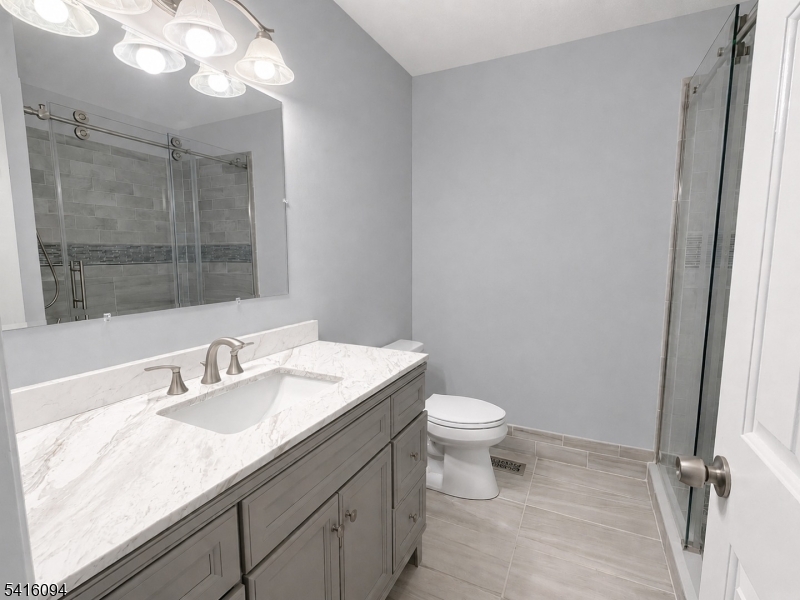 91 Delaware Lane, Unit 91 Somerville, NJ 08876 - Photo 17 of 32 a bathroom with a sink a toilet and a mirror