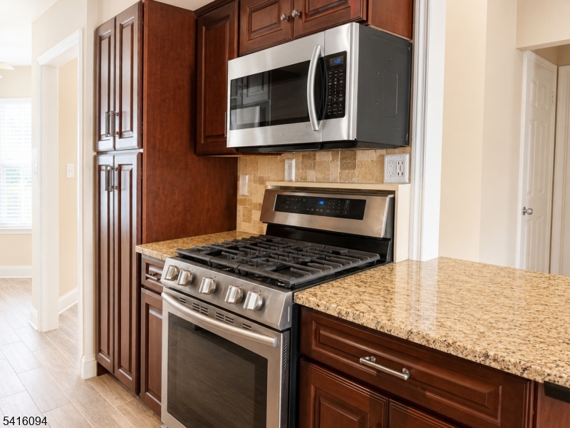 91 Delaware Lane, Unit 91 Somerville, NJ 08876 - Photo 5 of 32 a kitchen with granite countertop a stove and a microwave