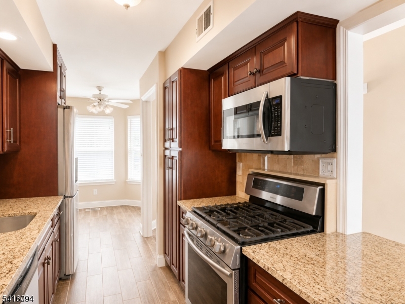91 Delaware Lane, Unit 91 Somerville, NJ 08876 - Photo 6 of 32 a kitchen with stainless steel appliances granite countertop a stove a refrigerator and a microwave