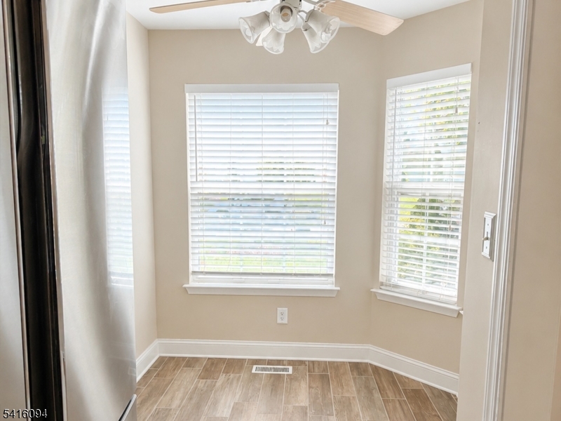 91 Delaware Lane, Unit 91 Somerville, NJ 08876 - Photo 7 of 32 a view of empty room with wooden floor and fan