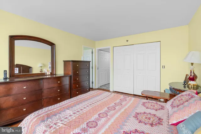 a bedroom with a bed and a dresser with mirror