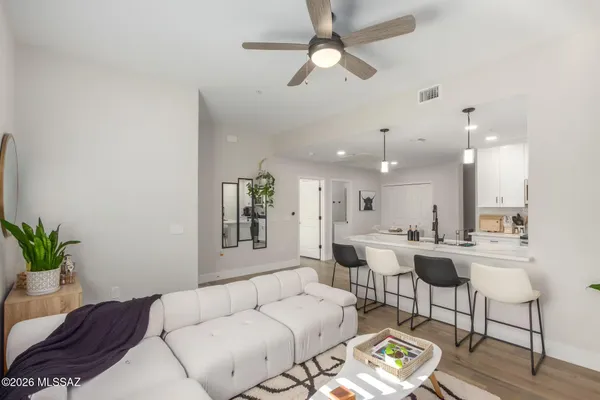a living room with furniture kitchen view and a chandelier