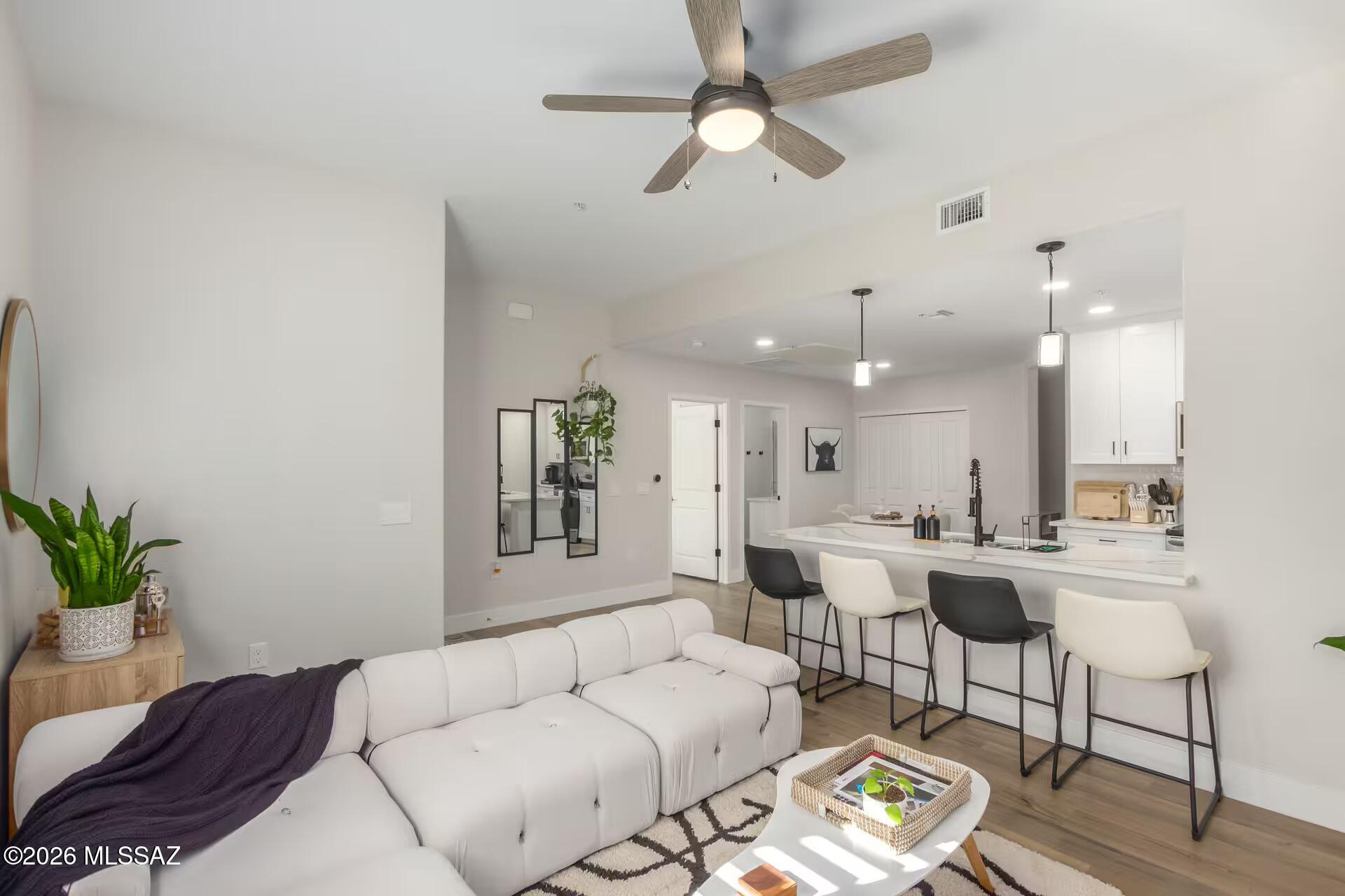 2036 East River Road, Unit 104 Tucson, AZ 85718 - Photo 1 of 23 a living room with furniture kitchen view and a chandelier