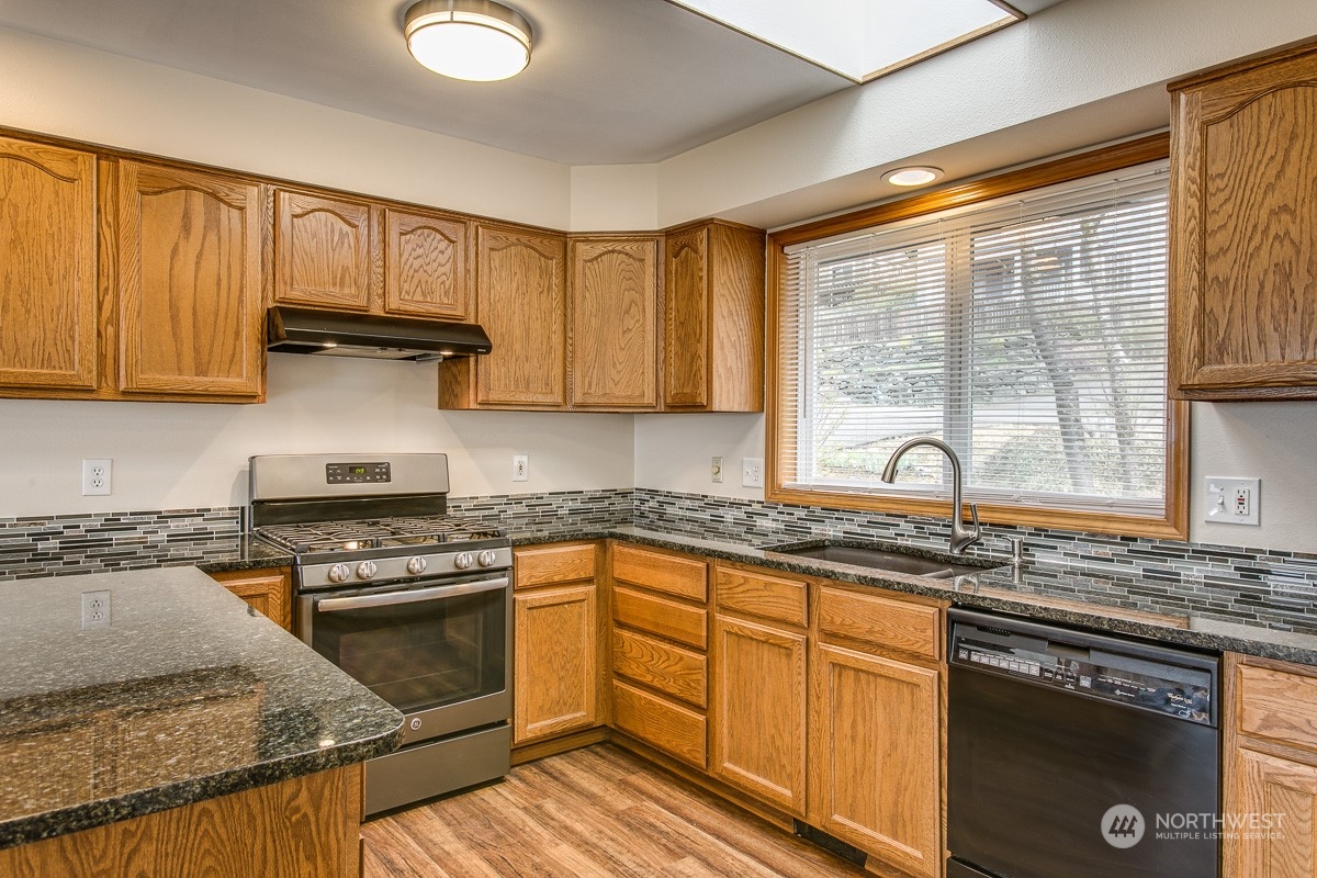 1818 35th Street Bellingham, WA 98229 - Photo 8 of 39 a kitchen with granite countertop wooden cabinets a sink and a stove
