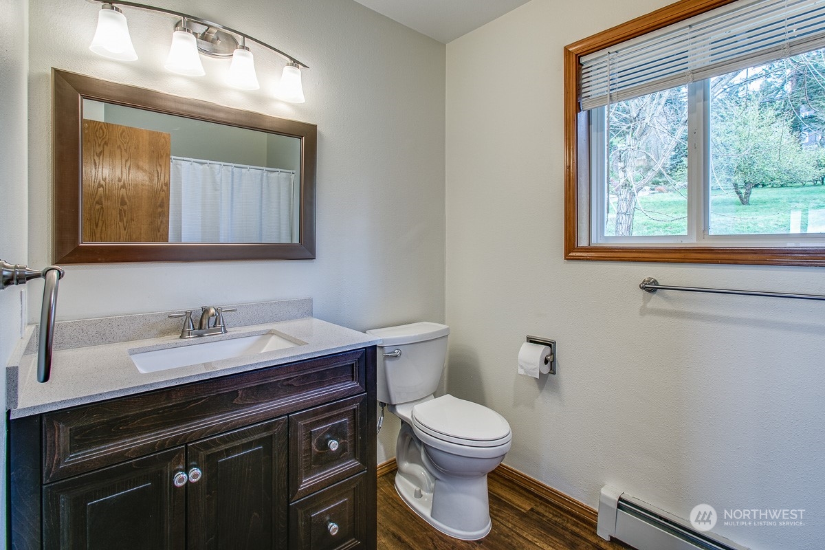 1818 35th Street Bellingham, WA 98229 - Photo 10 of 39 a bathroom with a toilet a sink a vanity and mirror