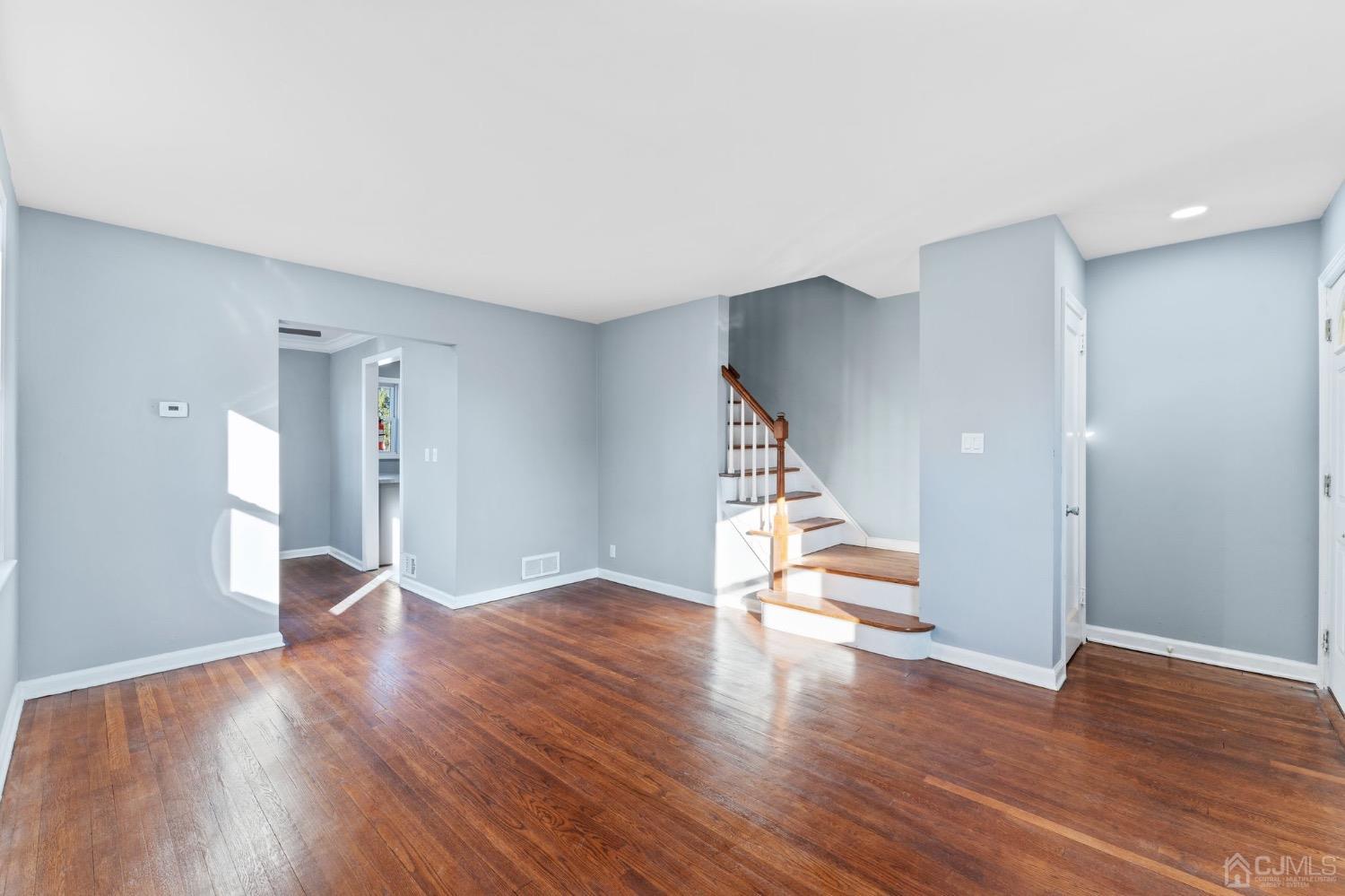 425 Crows Mill Road Fords, NJ 08863 - Photo 4 of 16 a view of an empty room with wooden floor and stairs