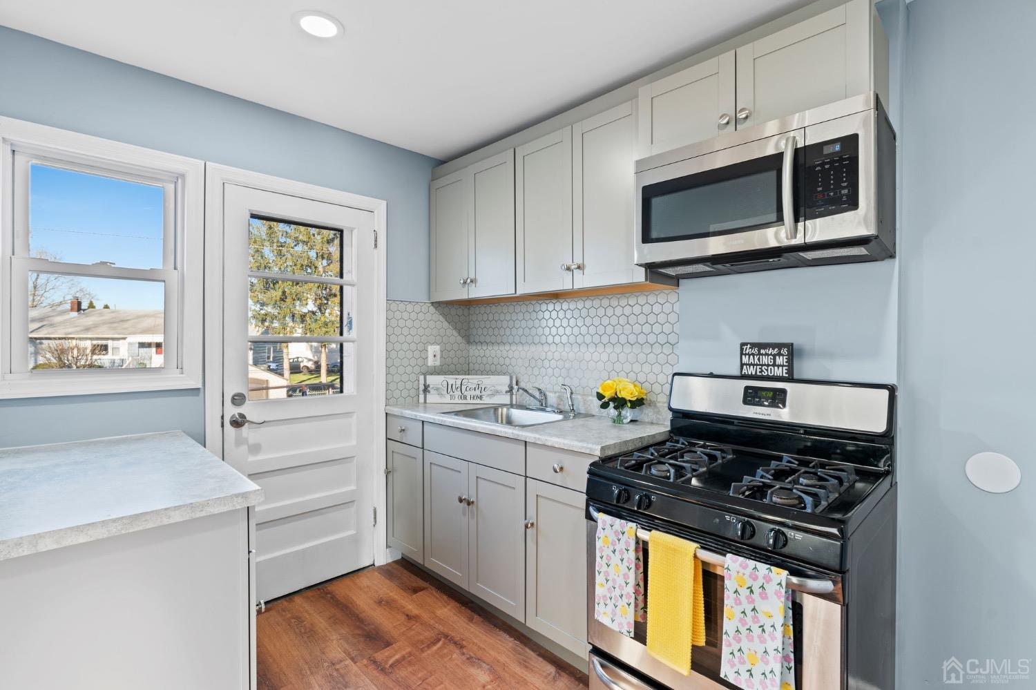 425 Crows Mill Road Fords, NJ 08863 - Photo 8 of 16 a kitchen with stainless steel appliances a stove a sink cabinets and a window