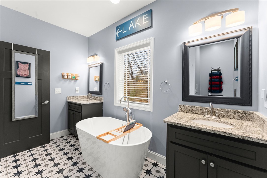 97 Cherokee Road Toccoa, GA 30577 - Photo 12 of 30 This bathroom features a deep soaking tub, dual vanities, and striking tile flooring.