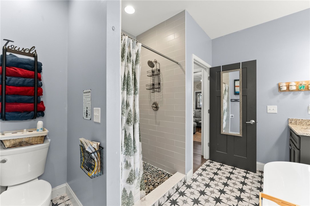 97 Cherokee Road Toccoa, GA 30577 - Photo 13 of 30 This bathroom features unique patterned tile flooring, a sleek shower, and granite counters.