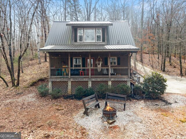 97 Cherokee Road Toccoa, GA 30577 - Photo 6 of 30 This charming cabin is surrounded by nature, featuring a welcoming porch and a cozy fire pit.