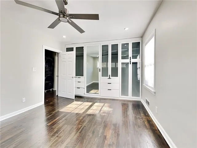 a view of a hallway with wooden floor and a ceiling fan