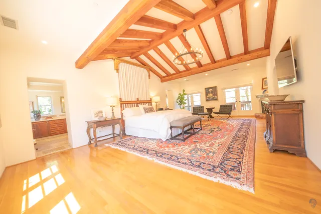 a living room with couch and a dining table with wooden floor