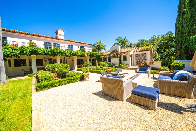 a view of a patio with couches table and chairs and potted plants