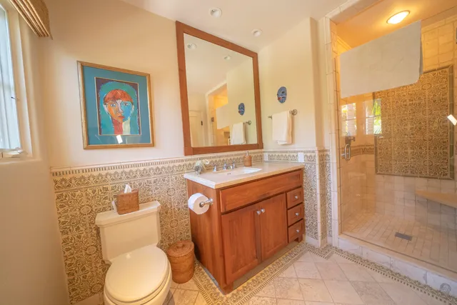 a bathroom with a granite countertop toilet sink and mirror