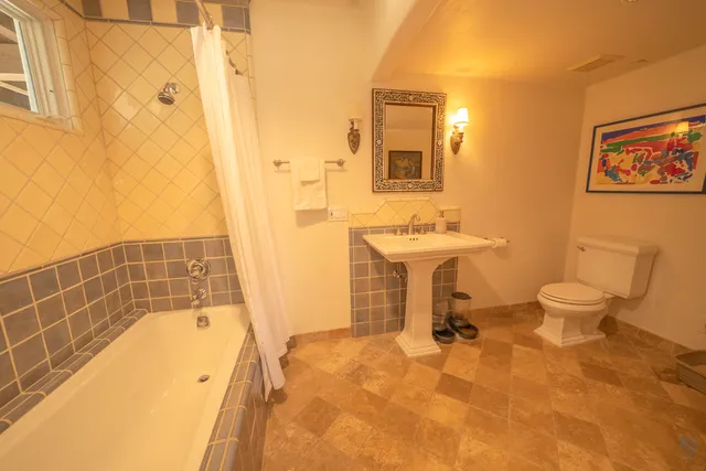 a bathroom with a sink a toilet a mirror and shower